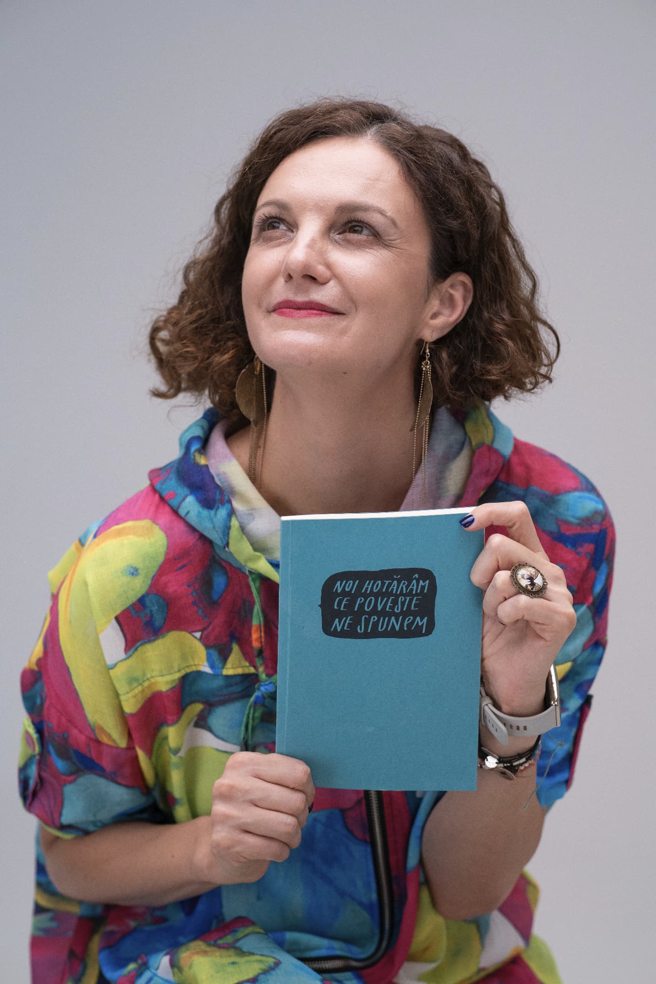 Veronica Țurlea ținând un caiet cu mesajul «Noi hotărâm ce poveste ne spunem»